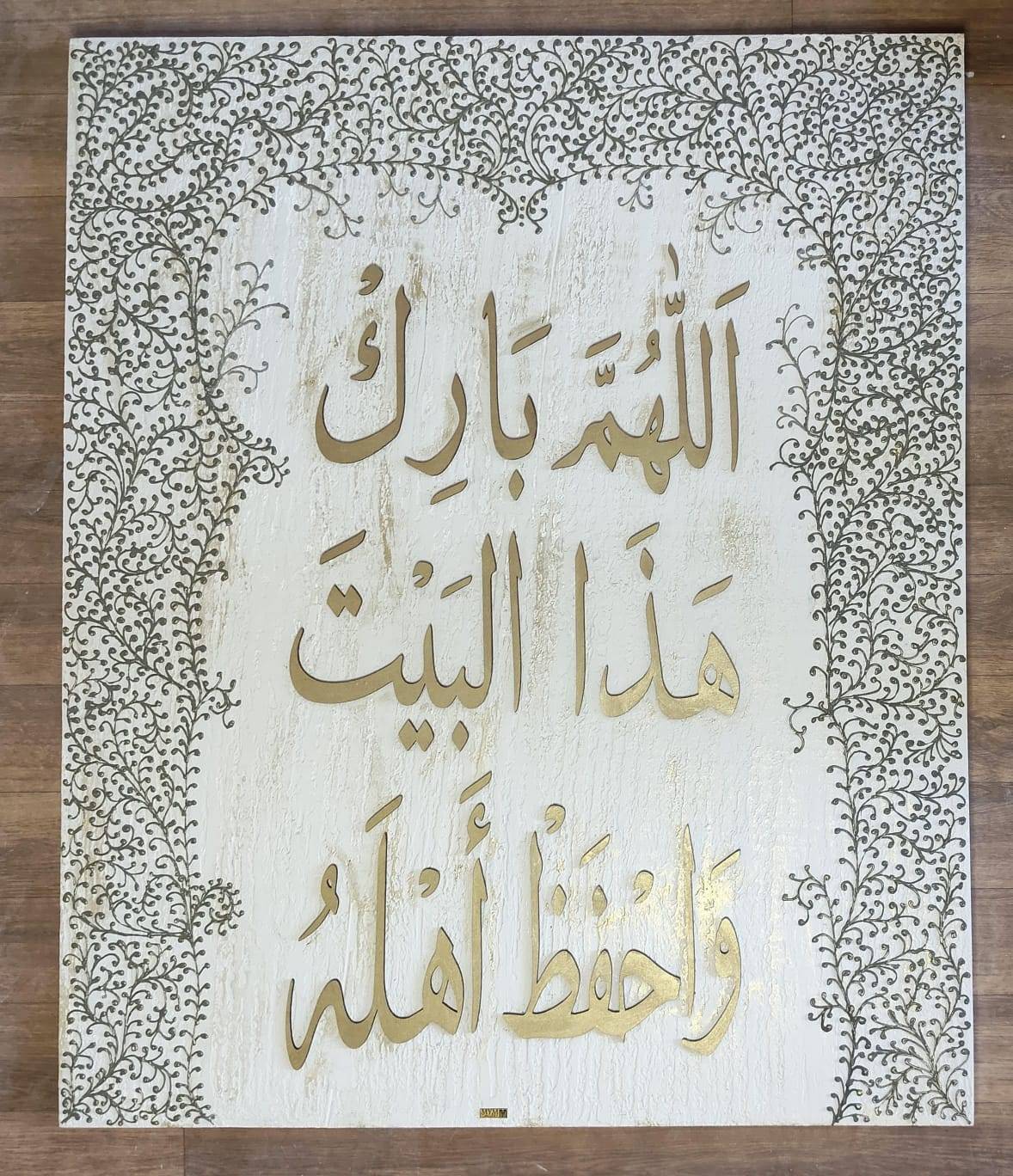 Gilded Arabic calligraphy within a border of fine vines on a white board