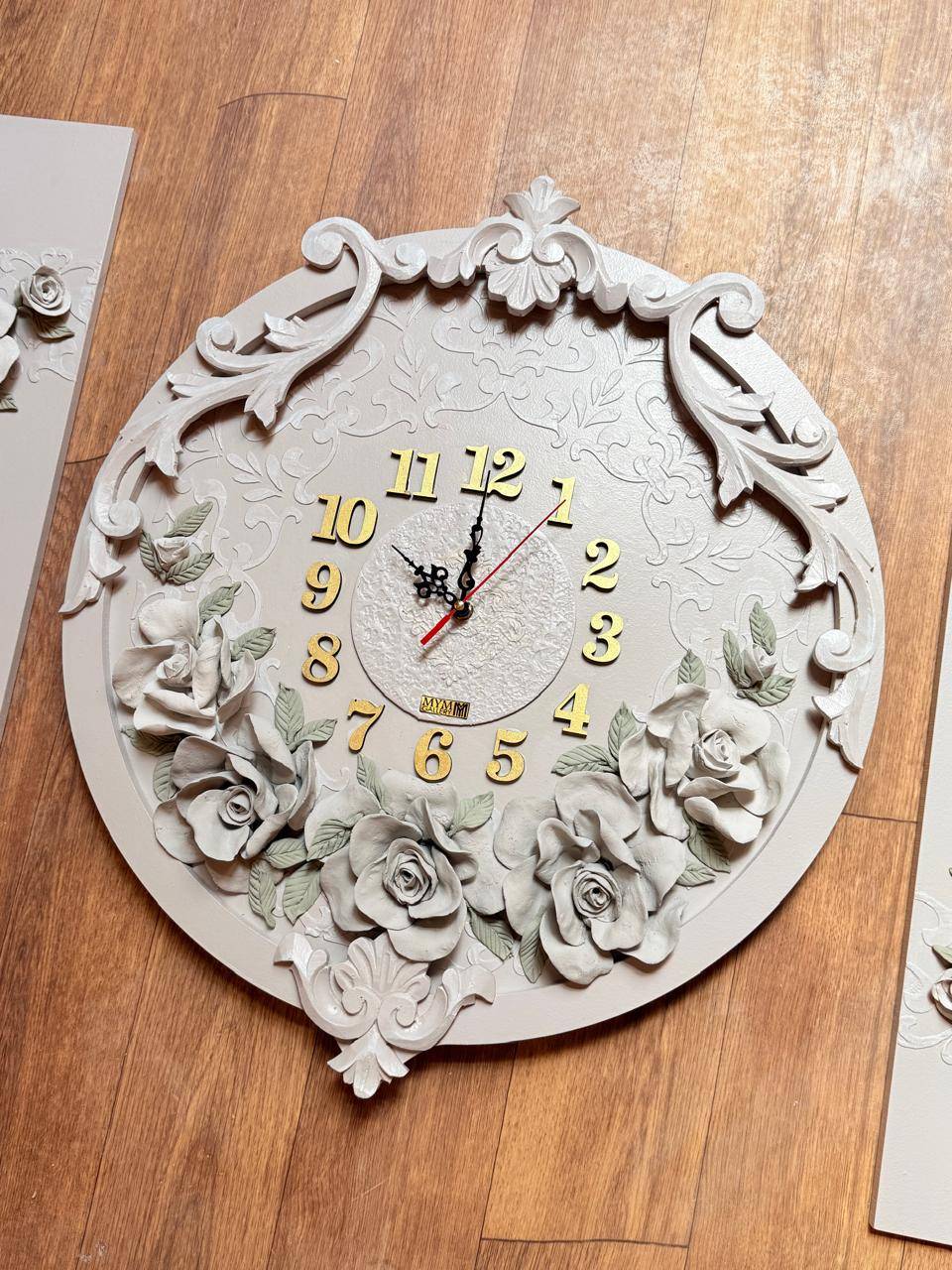 Round ivory wall clock with carved scrolls, sculpted roses and gold numerals