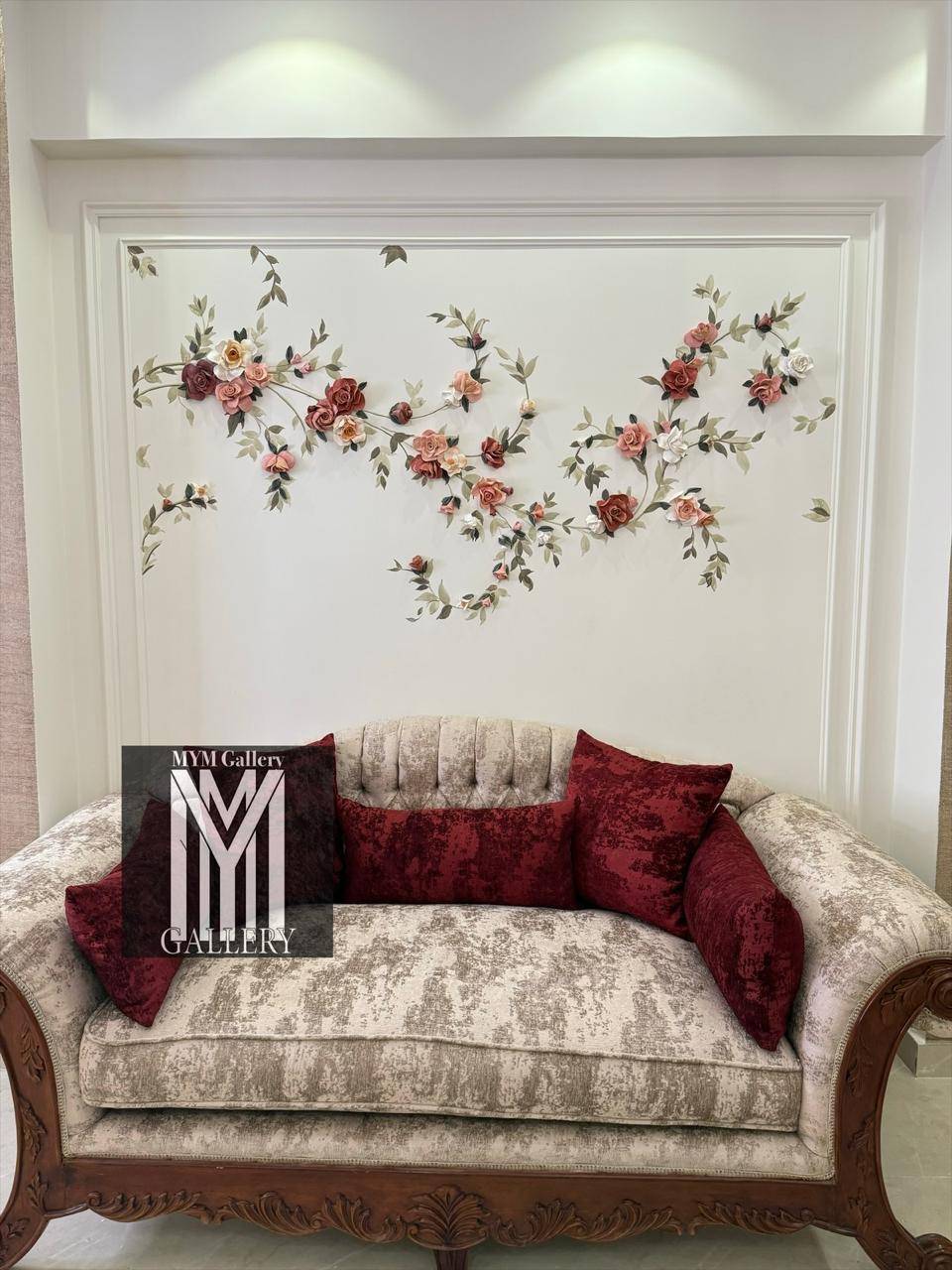 Sculpted roses and vines across a white panelled wall above a sofa